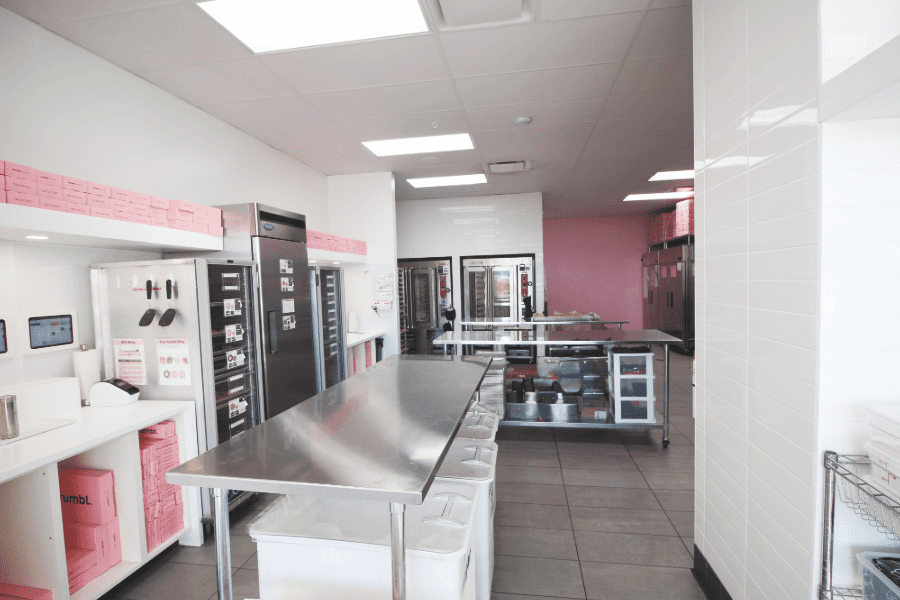 Back area with pink  accent wall at Crumbl Cookies.